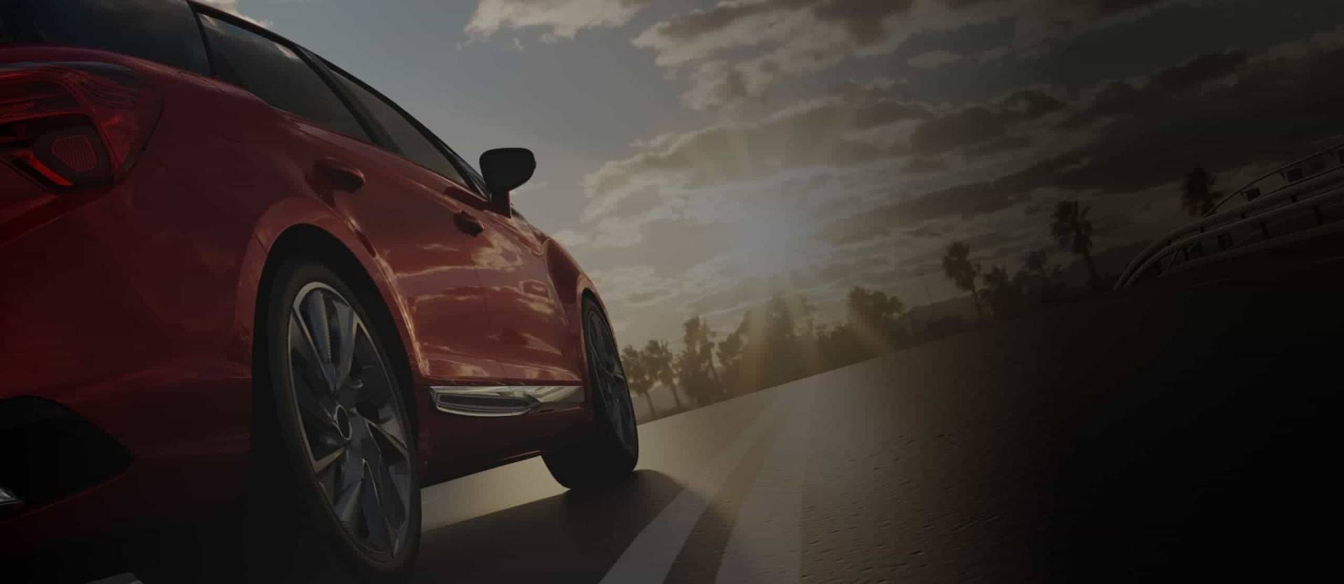 Rotes Auto fährt bei Sonnenuntergang auf einer leeren Straße – Symbol für Mobilität und Freiheit